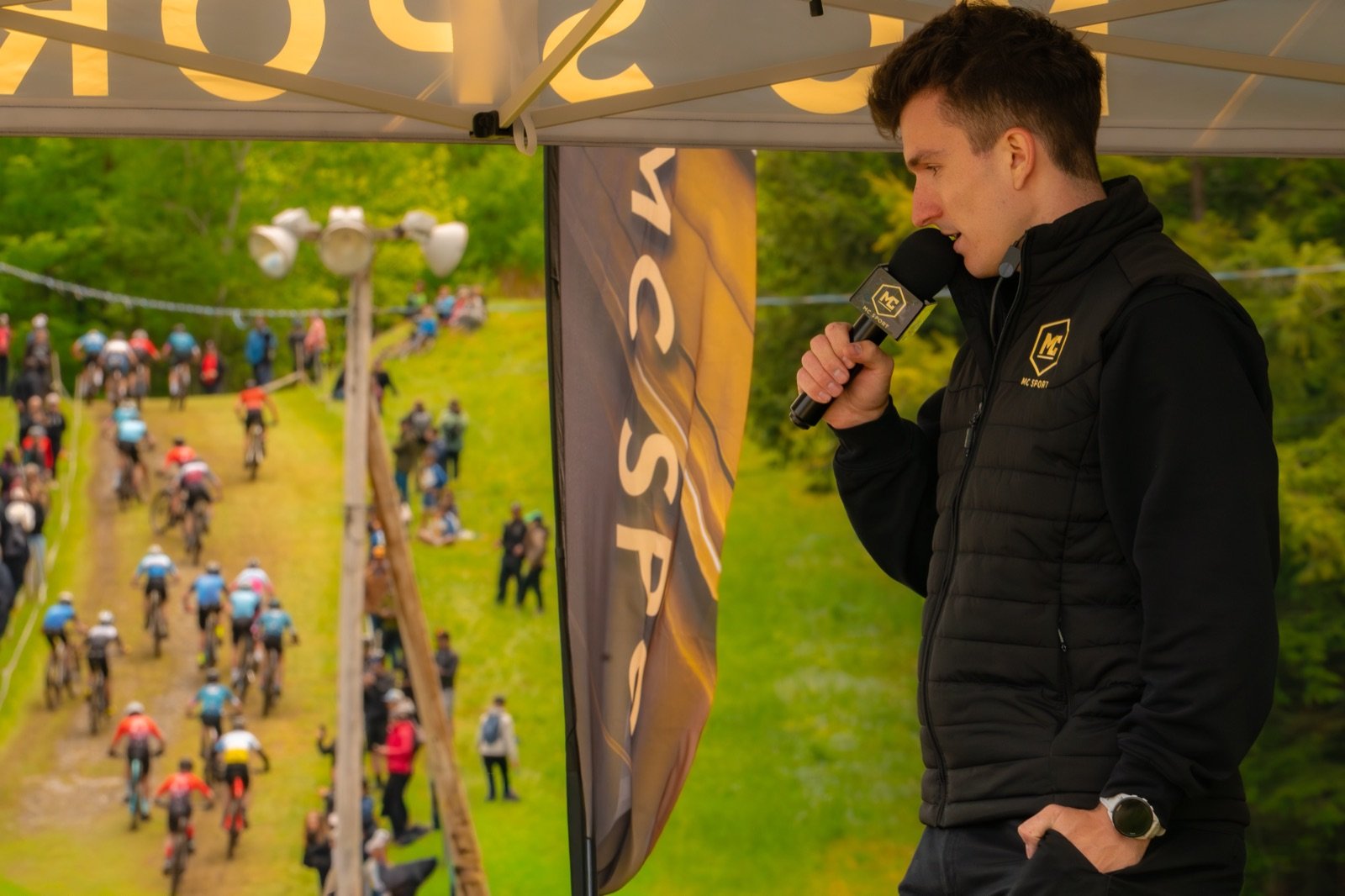 Descripteur-analyste MC Sport au micro pendant une course de vélo de montagne